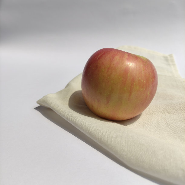 一些新鲜的红苹果在白色的草地上。图片下载