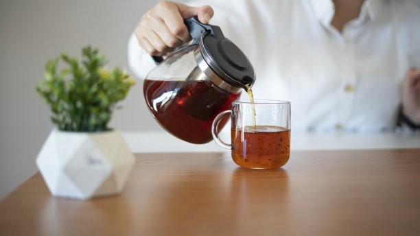 女商人在办公桌前倒茶图片下载