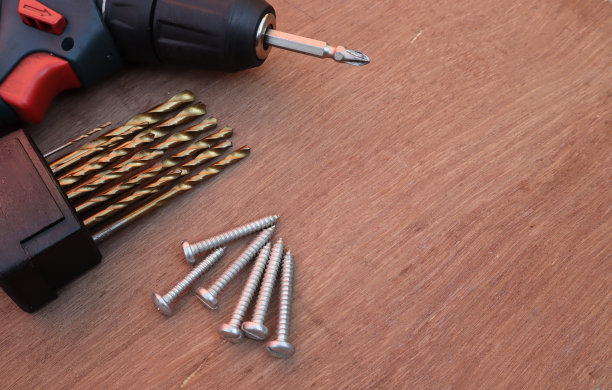 在胶合板背景上的一套镀锌螺丝和由印度木匠连接木材材料的工具。图片下载