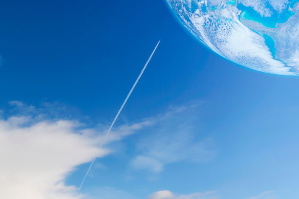 一架带着航迹或蒸汽尾迹的私人喷气式飞机在蓝天上飞向行星图片下载