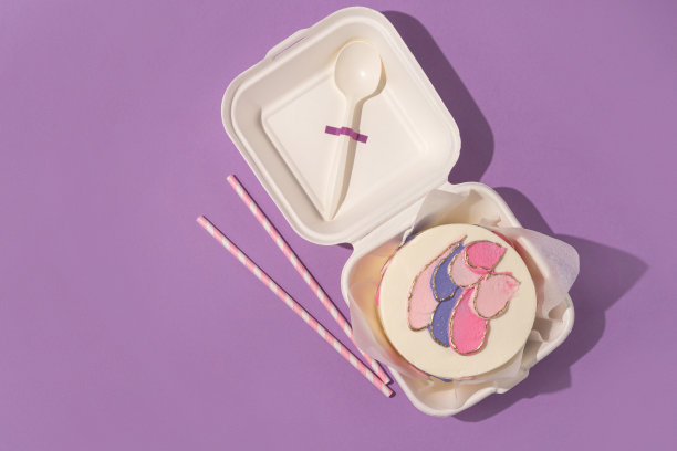 小便当蛋糕在盒子里，紫色背景图片下载