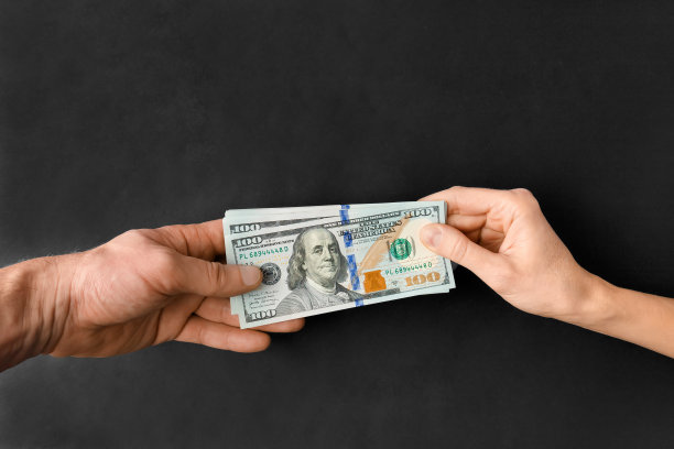 钱在黑色背景上从一只手传递到另一只手图片下载