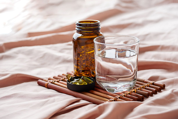 欧米茄3油胶囊和水杯放在托盘上。脂肪酸营养补充，支持健康。图片下载