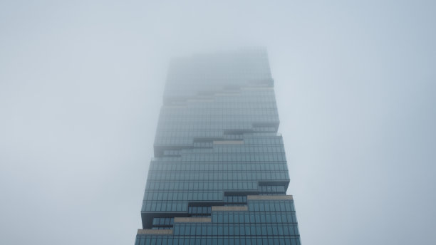在雾蒙蒙的阴天仰望摩天大楼图片下载