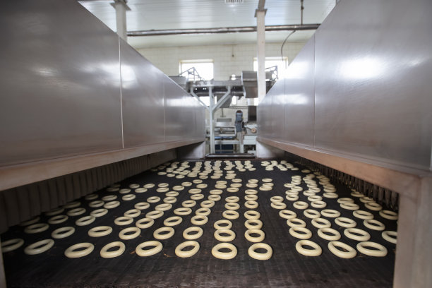 在面包房的工业传送带上，甜甜圈在出售前被烘干。图片下载