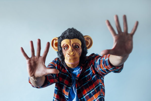 戴着猴子面具的人在打手势。图片下载