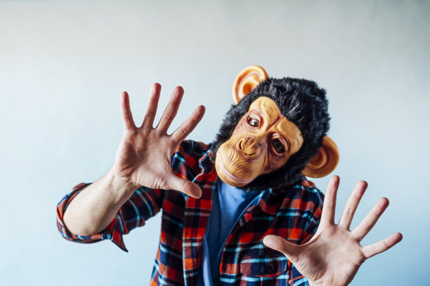 戴着猴子面具的人在打手势。图片下载