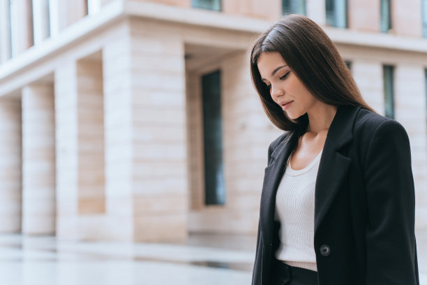 不开心的亚洲年轻女商人站在街上，在坏消息、麻烦、错误后沮丧地向下看。关注的韩国女学生考试不及格。失败，悲伤的概念。危机。图片下载