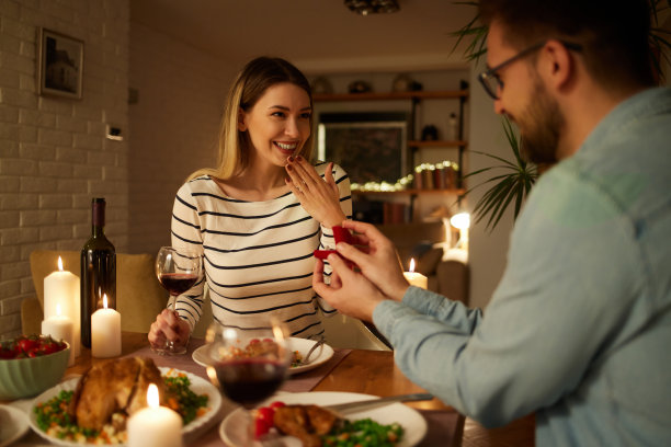 惊喜的女人在家里的浪漫晚餐上得到了求婚图片下载