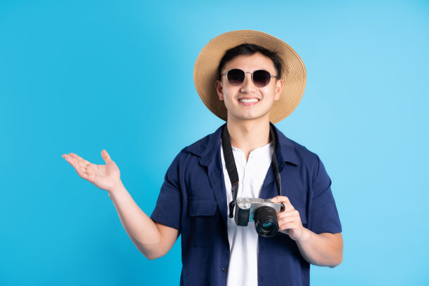 旅行亚洲人的肖像，孤立的蓝色背景图片下载