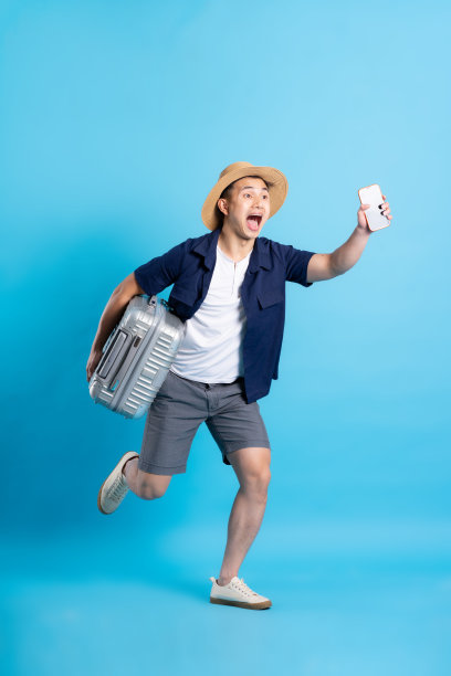 旅行亚洲人的肖像，孤立的蓝色背景图片下载