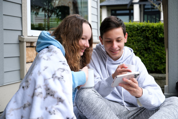 男孩，女孩，在互联网上发现一些有趣的东西，拿着手机，水平，快乐，愉快的交流，青少年，喝茶，在门廊上，咖啡，真诚的关系，运动装，欧美孩子图片下载