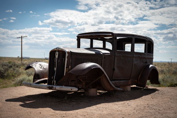 老式的棕色汽车停在沙漠般的环境中图片下载