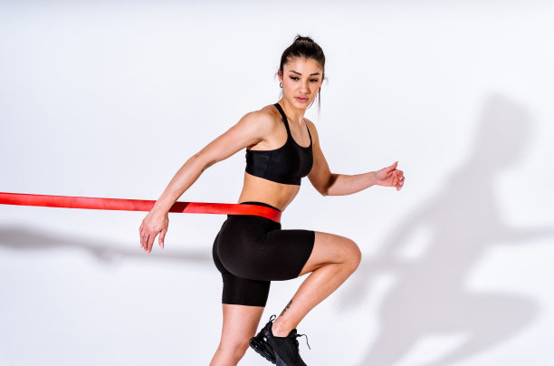 年轻的女运动员在健身房使用运动器材训练图片下载