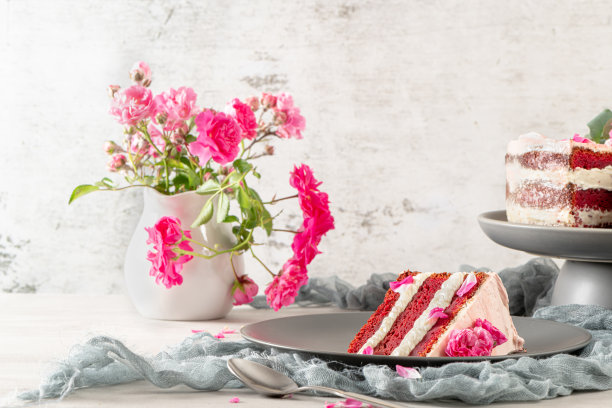 红色丝绒裸蛋糕，新鲜玫瑰和瑞士奶油在厨房的工作台上图片下载