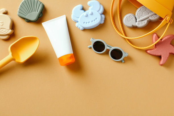 儿童和婴儿防晒霜和沙模具的颜色背景。防晒概念图片下载