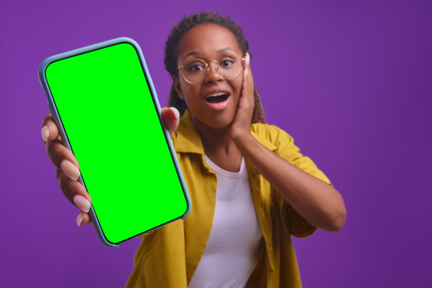 年轻快乐的非裔美国妇女对着镜头拿出绿屏手机图片下载