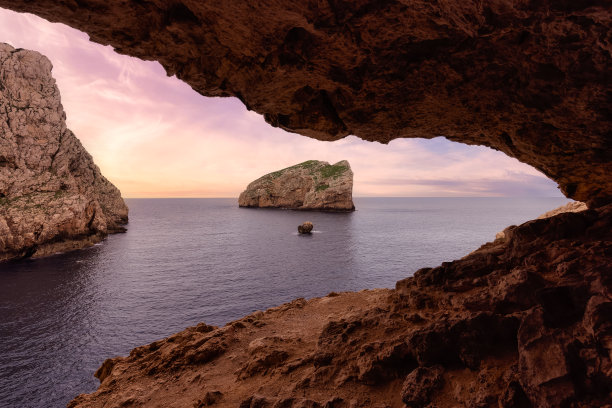 岩石海岸上的洞穴和地中海上的悬崖。意大利撒丁岛。背景。图片下载