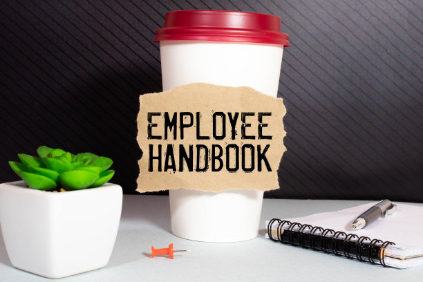 经营理念。在一个白色的表面上，有一杯咖啡，一支铅笔和一个写着“员工手册”的记事本。图片下载