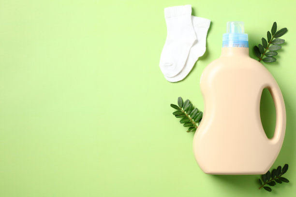 婴儿洗衣液和袜子的绿色背景，环保，俯视图图片下载