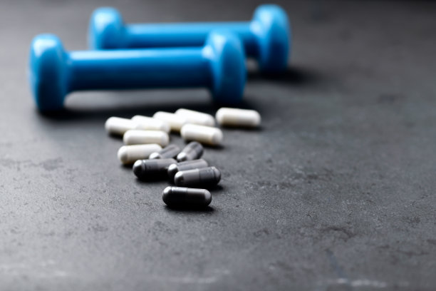 BCAA和创造性胶囊。深色石材背景上的健身食品补充剂。软的焦点。关闭了。副本的空间。图片下载