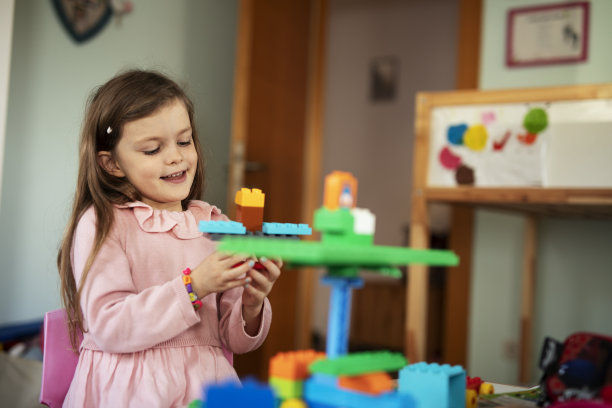 可爱的女孩在家里玩玩具。图片下载