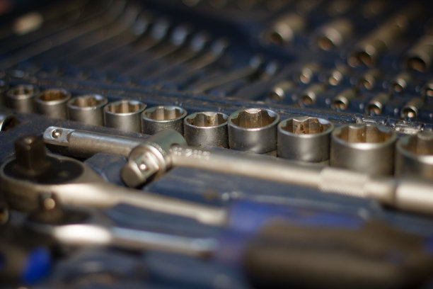 修理工的工具箱。箱子里有一套螺丝刀和扳手。金属工具放在一个满是灰尘的盒子里。工具箱:装在塑料盒里的一套工作工具图片下载