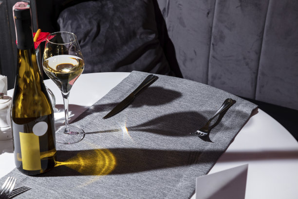 一张有餐巾、餐具、酒瓶和酒杯的桌子图片下载