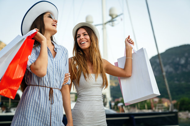 时尚女性带着购物袋走在街上。消费主义，销售，购买，购物概念。图片下载