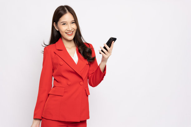 快乐的年轻亚洲商业女性拿着智能手机孤立在白色背景上图片下载