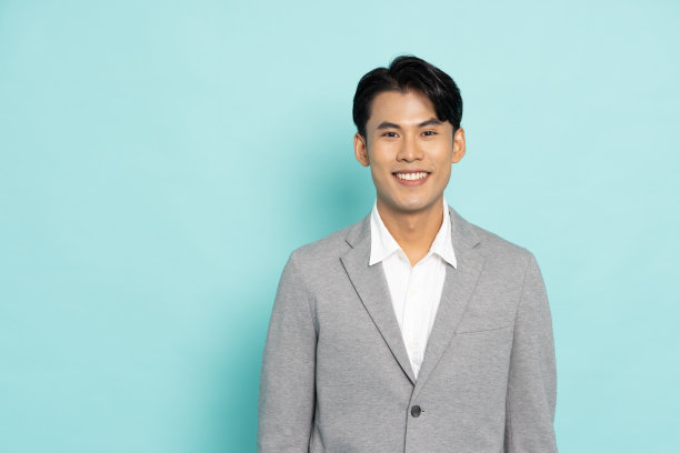 微笑的年轻亚洲商人孤立在绿色背景图片下载
