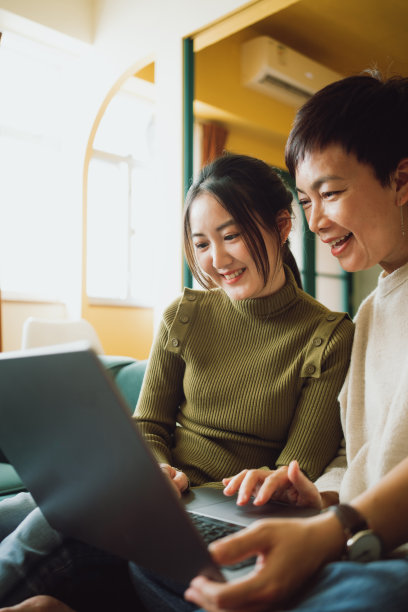 亚洲母亲和女儿在家里使用笔记本电脑图片下载