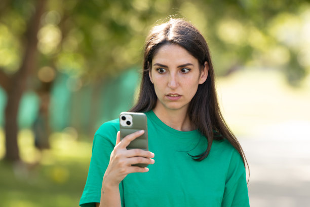 惊讶的不相信女孩看着手机图片下载