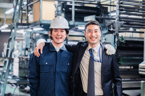 工人和管理人员在工厂里肩并肩地工作图片下载