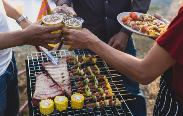 干杯!一群年轻的男性朋友在家里的户外烧烤派对上喝啤酒。图片下载
