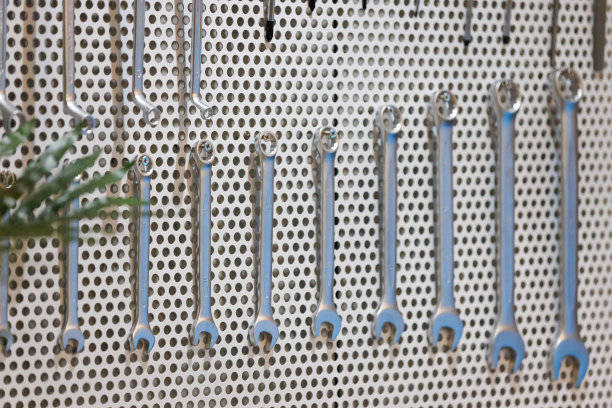 工具挂在车间的墙上。扳手挂在车库的钢钉板上。图片下载