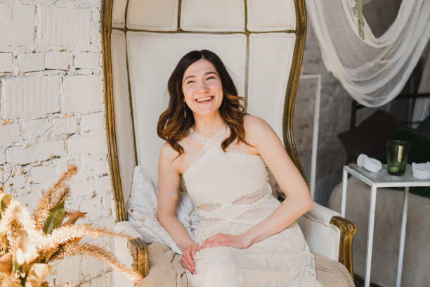 美丽的年轻白人女子在白色蕾丝连衣裙摆姿势的照片在装饰复古的房间。图片下载