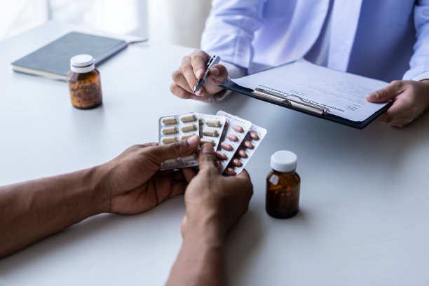 穿着白色医疗服的男医生与男患者讨论结果或症状或医生在医院给顾客提供药物建议。图片下载