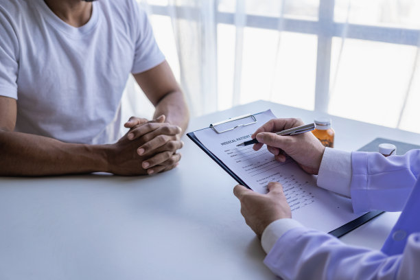 穿着白色医疗服的男医生与男患者讨论结果或症状或医生在医院给顾客提供药物建议。图片下载