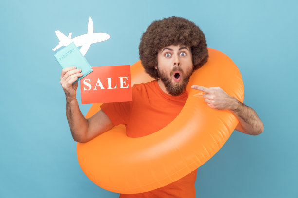 男子与橙色橡胶环，持有护照文件和指向销售卡，旅游为低成本。图片下载