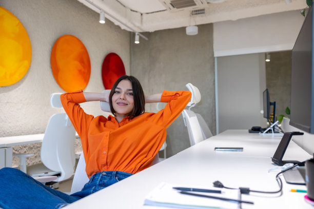 满足的公司员工在工作场所对着镜头摆姿势图片下载