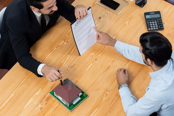 顶视图房地产经纪人计算税和利息与买家。狂热的图片下载