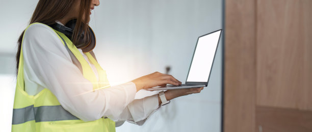 照片微笑女工程师与笔记本电脑在建筑工地图片下载