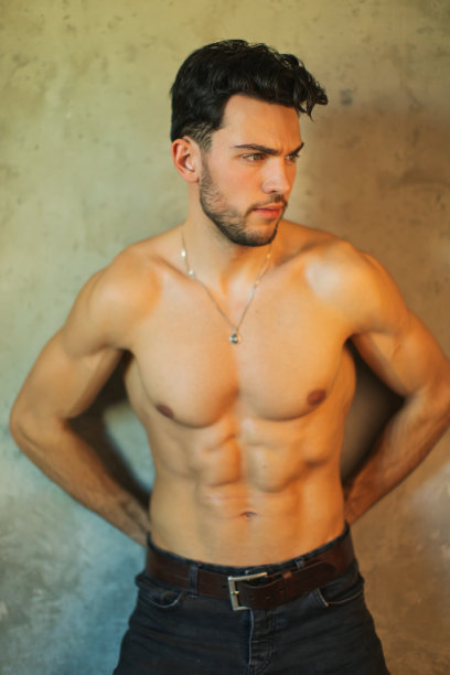 黑发男子在工作室的灰色背景。运动员。图片下载