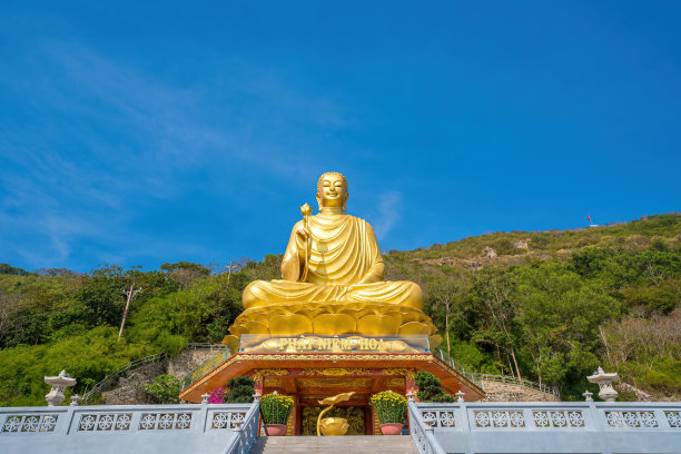 在越南凤头的全孔寺，Ariel观看手持莲花的金佛雕像，周末吸引游客来这里进行精神上的参观。旅行的概念。图片下载