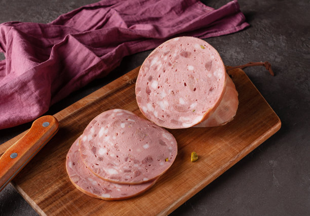 小牛肉香肠片放在木板上，深色照片图片下载