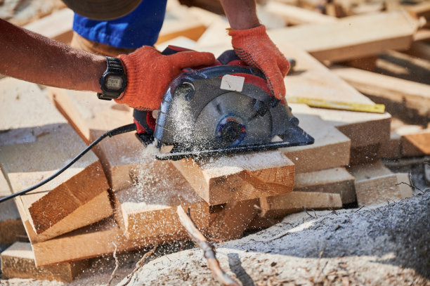 木匠在建造木结构房屋时使用圆锯切割木板。图片下载