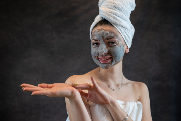 女性面部用灰色气泡面膜作为抗衰老治疗，使肌肤完美隔离于黑色图片下载