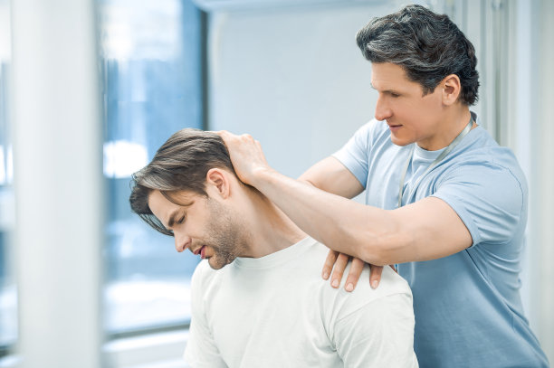 理疗师治疗病人的颈部图片下载