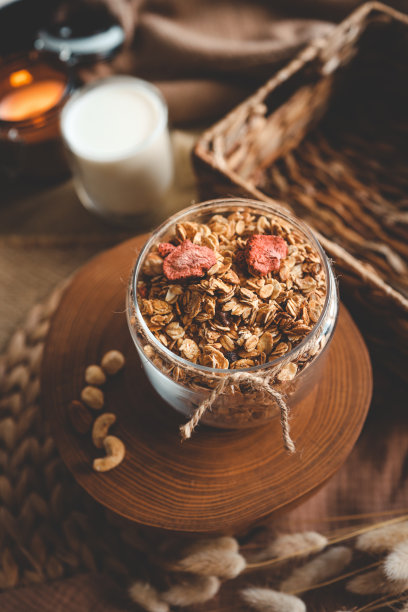 自制的格兰诺拉麦片放在玻璃罐里，背景是牛奶，蜡烛和装饰，早上好图片下载